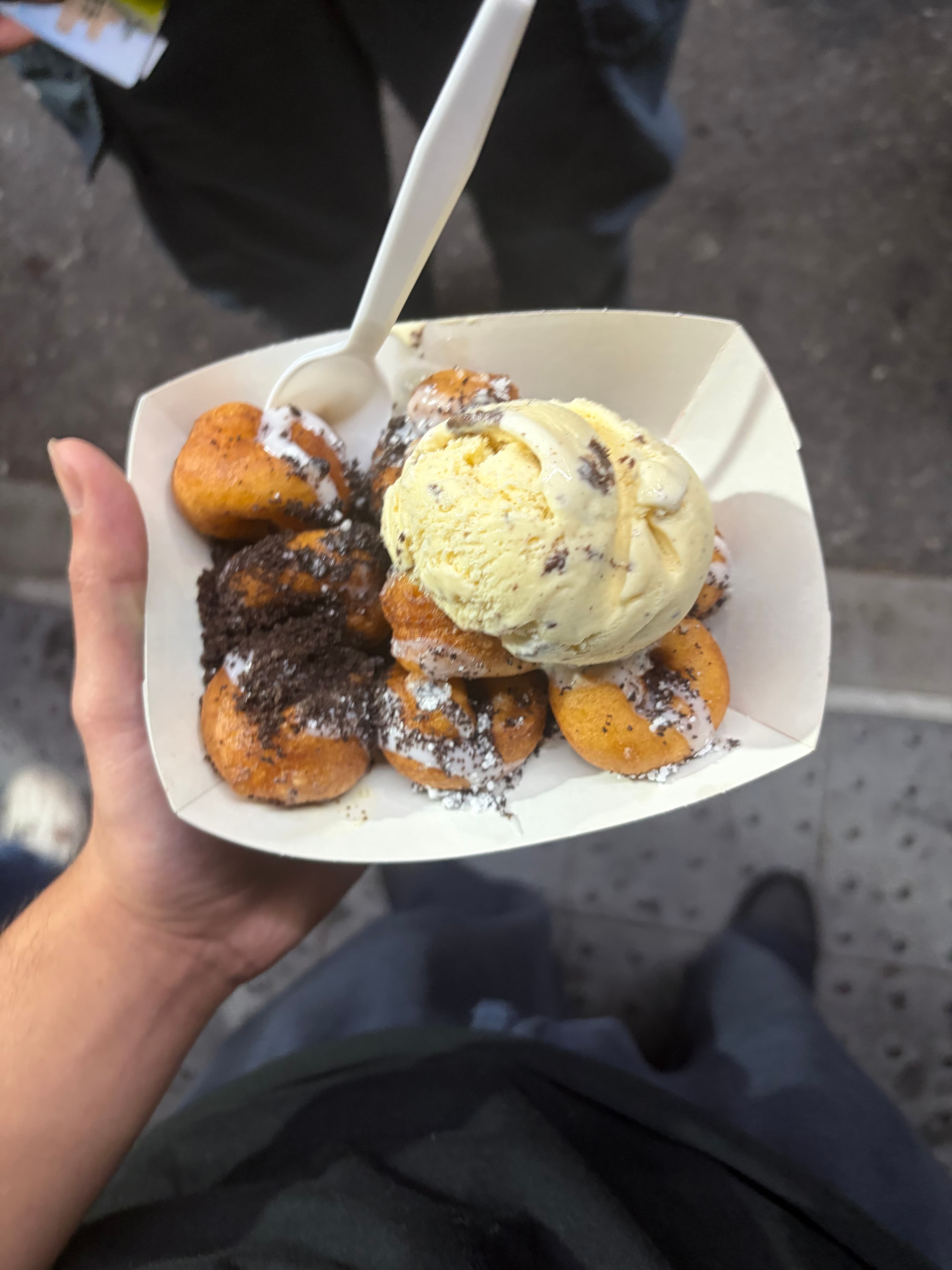 Fried dessert bites topped with ice cream and cookie crumbs