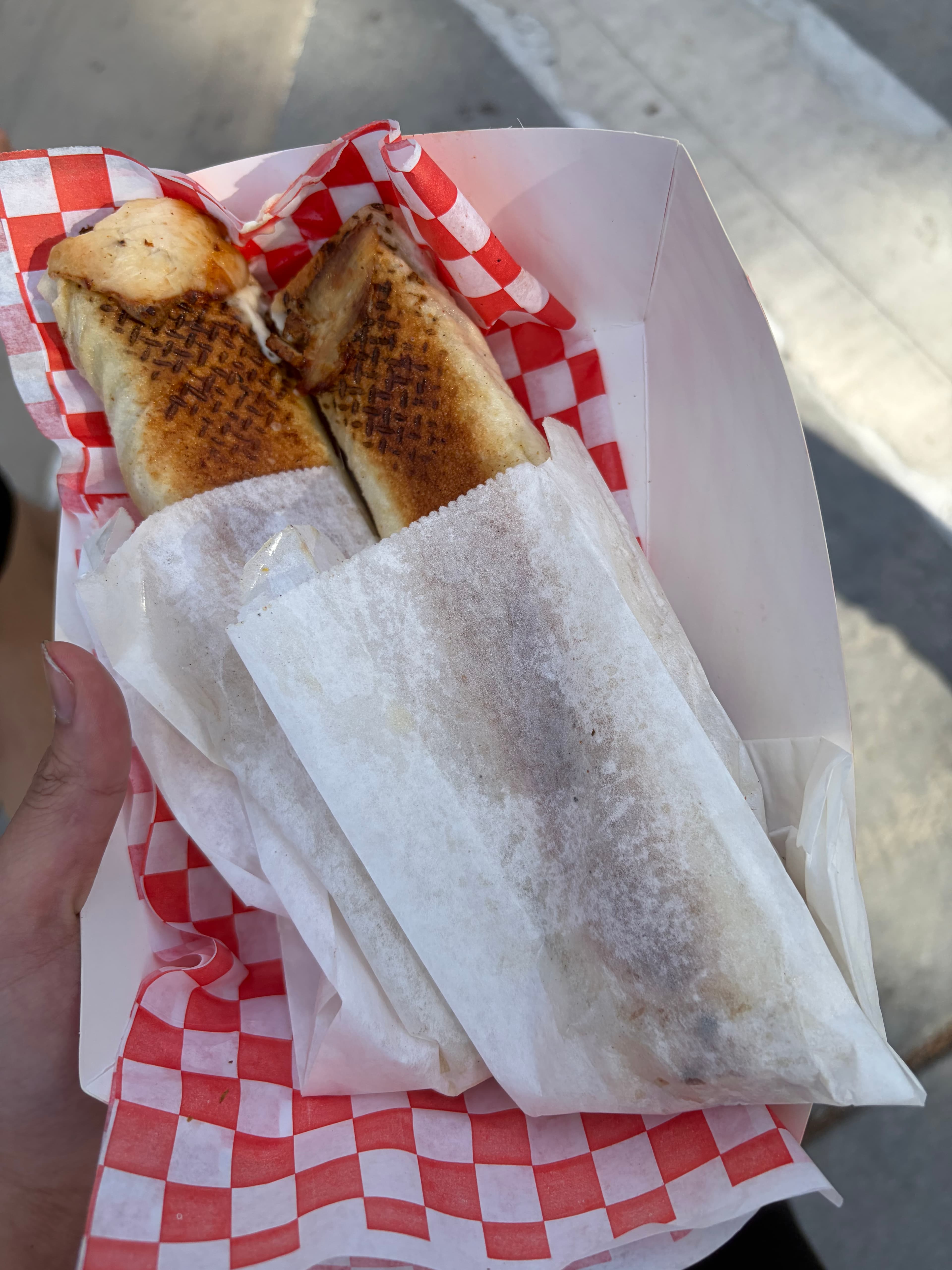 Two grilled wraps in a paper tray