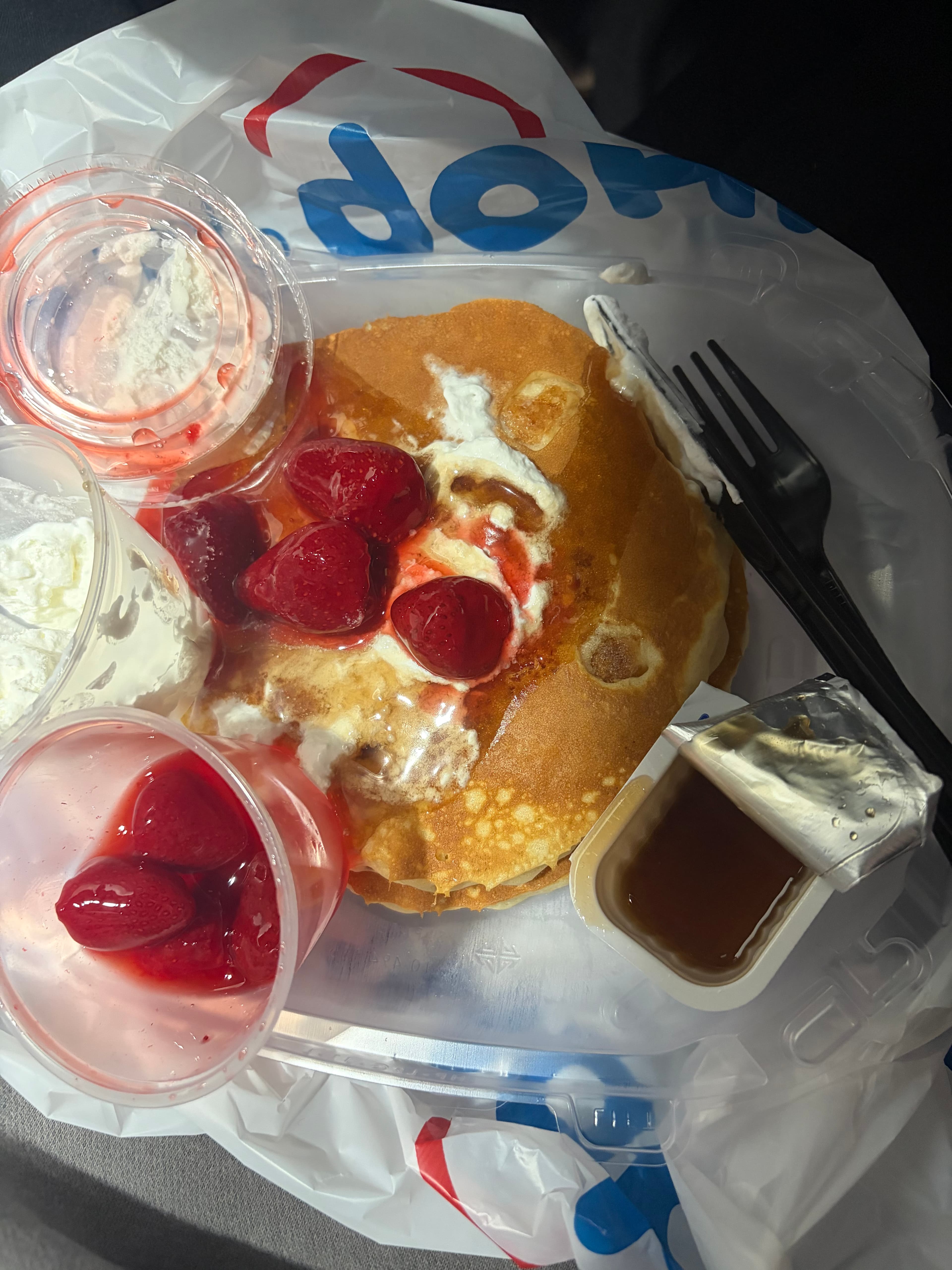 Pancakes with strawberries, whipped cream, and syrup