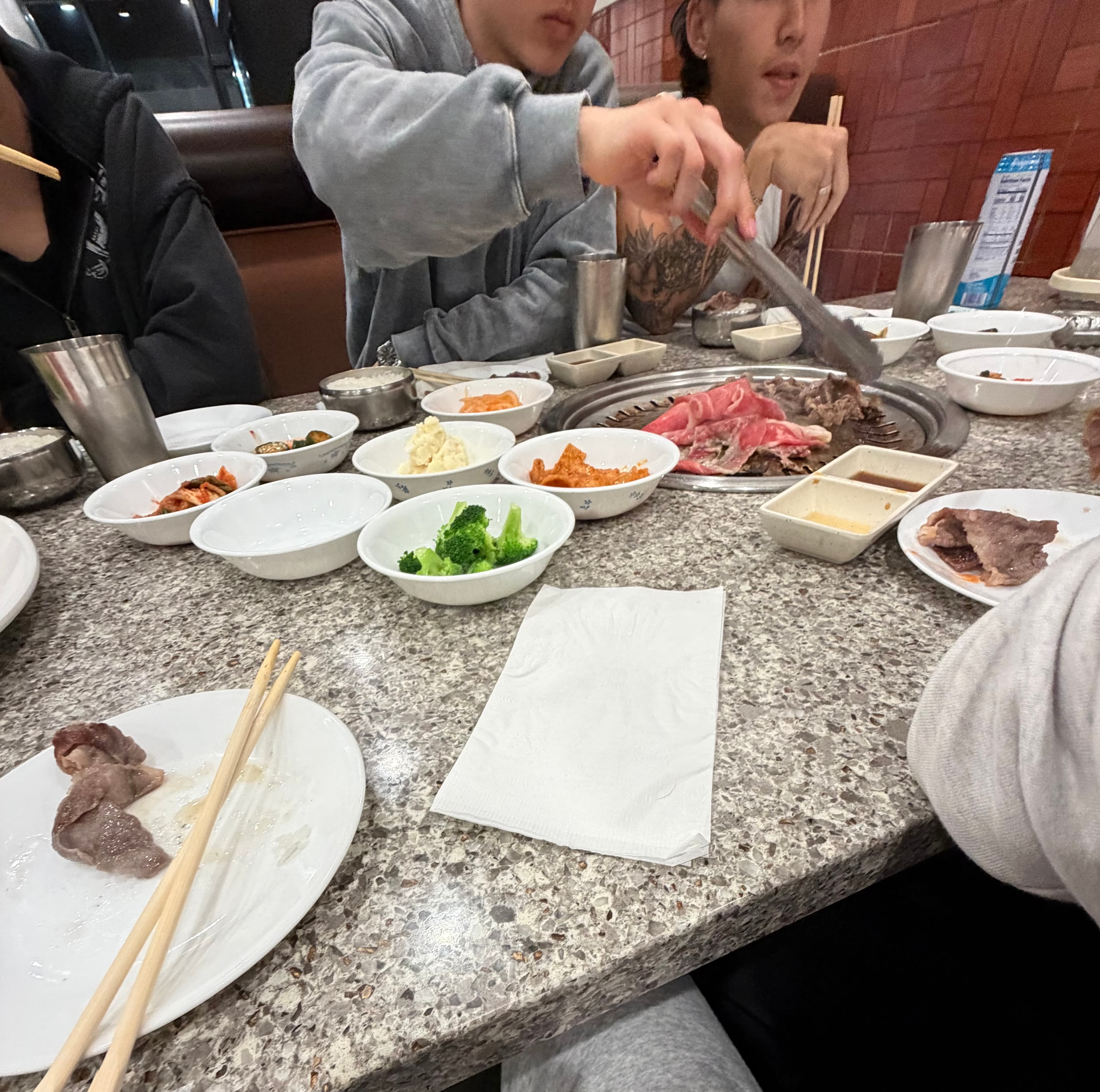Korean barbecue table with banchan and grilled meat