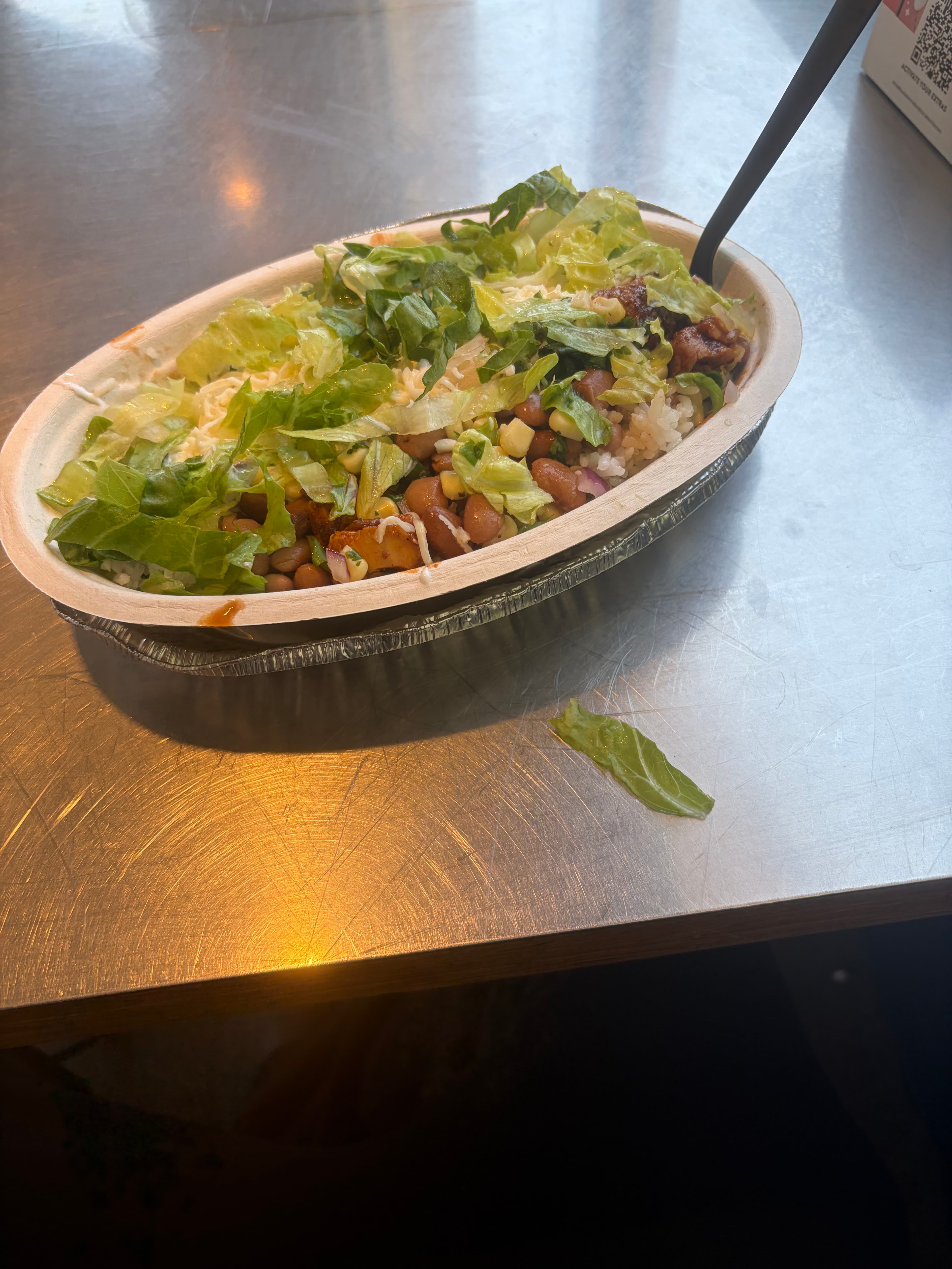 Burrito bowl with rice, beans, corn, lettuce, and salsa